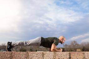 man is doing push ups outdoorsort