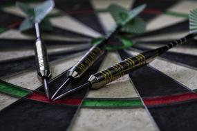 three Darts together on target