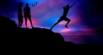 Silhouettes of the jumping boys, on the beautiful, rocky sea shore, at colorful sunset with clouds