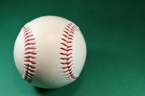 White Baseball at green background
