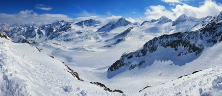 Beautiful, snowy mountains in Stubaital, Austria, under the blue sky with white clouds