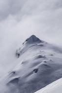 Mountain summit covered with snow in fog