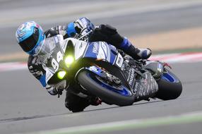 Motorcycle Racer on track turn close-up on blurred background