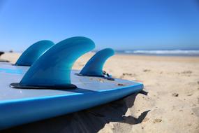 blue water sports board on the beach close up
