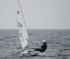 man in sailing boat on grey baltic sea