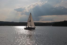 cloudy sky over a sailboat on the lake