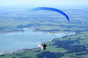 Aerial view of skydiver floats over the valley to the lake