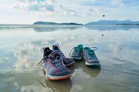 sports shoes in the water on the coast close up