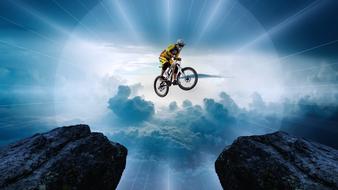 Man on the bike, jumping between the cliffs, at beautiful skyscape