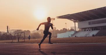 athlete runs in the stadium on a foggy morning