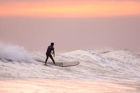 Surfer on wave at Sunset