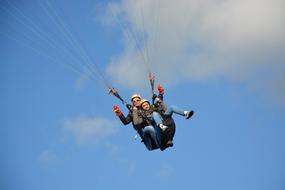 people paragliding in the blue sky