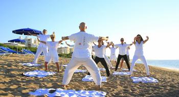 people are doing yoga on the beach