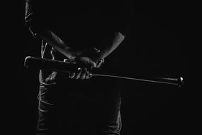 black and white photo of a man with a baseball bat