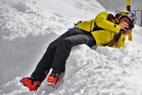 the snowboarder lies in the snow and takes pictures