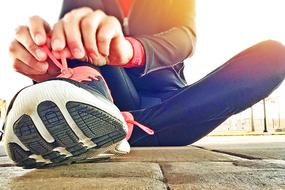 person in sports outfit sits on pavement