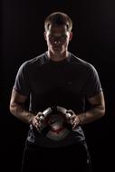 Soccer player with ball, low key portrait