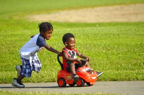 african children ride a toy car