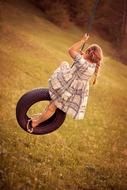 little girl on a swing in nature