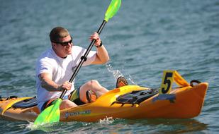 young man is kayaking with a version in his hands