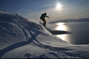 Skier jumping from hill at scenic winter landscape