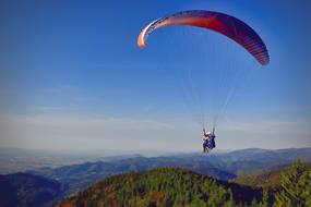 free soaring paragliders on the beautiful landscape with the mountains