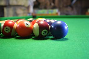 multi-colored balls on a green pool table