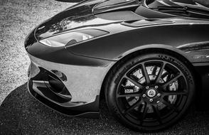 Black and white photo with the side view of the beautiful, shiny Lotus Evora car, with the shadow