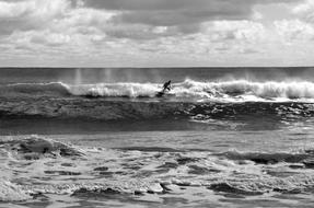 black and white picture of a surfer on waves