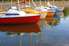 colorful boats are reflected in the water of the harbor