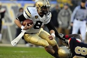 Football Runner in gold uniform on the grass