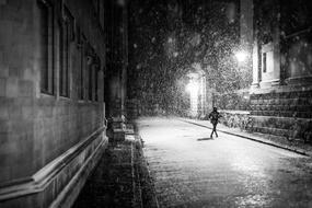 black and white photo of a lonely man on a night street