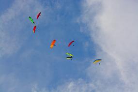 panoramic photo of multi-colored paragliders in the sky over France