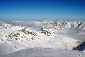 Landscape of the beautiful, snowy mountains in clouds in Austria, in winter, at blue sky