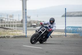 motorcyclist speeding on pavement at grid fence