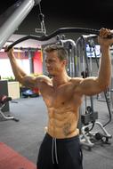 man shakes muscles in the gym