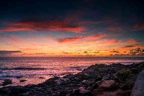 rocks by the ocean during sunset