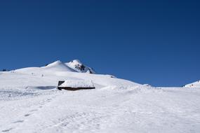 snow covered log cabin on mountain slope, austria