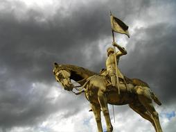 Joan Of Arc, low angle view of Gilded equestrian statue at stormy clouds, france, caen