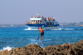 Paddleboarding, man with Paddle on board at coastline