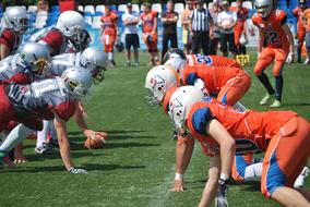 American Football teams kneeling on pitch