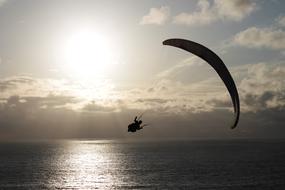 parachutist flies low over the sea