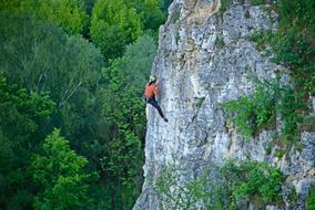 lone rock climber at the top of the mountain