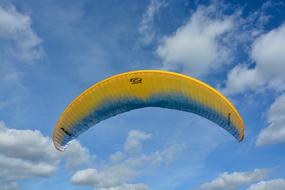 Paragliding at the blue sky background with white clouds