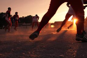 feet of soccer players at sunset