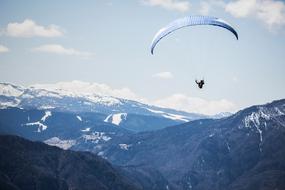 skydiver flies over the snowy mountains