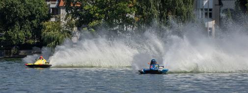 People on the colorful water boats, on the motor boat race, near the shore