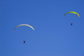 two parachutists against a blue sky over France
