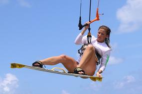 girl on a kitesurf board against the sky