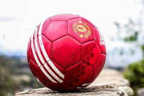 red soccer ball close up on blurred background